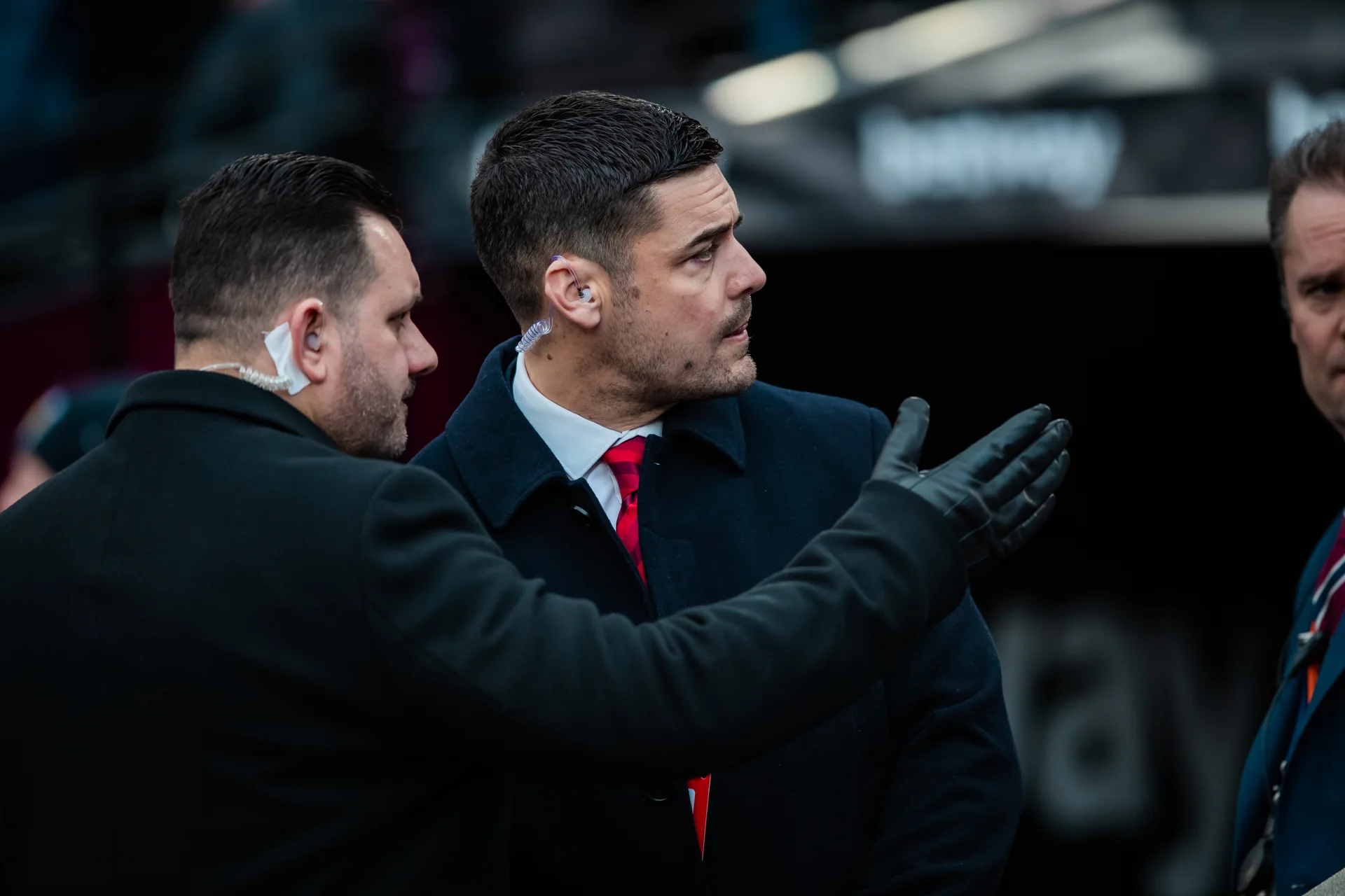 Close protection team coordinating at a busy public event